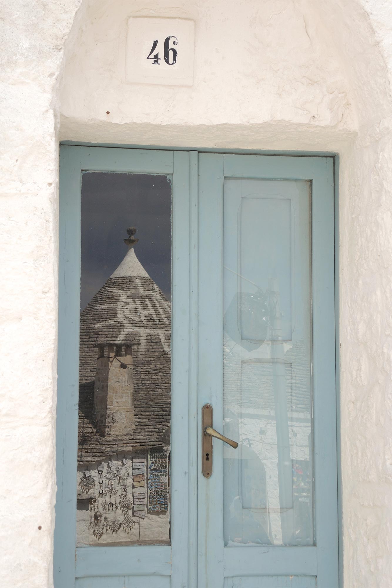 Alberobello Un trullo di Alberobello riflesso su una finestra © Roberta Reggiani, concorso fotografico TCI Borghi d'Italia
