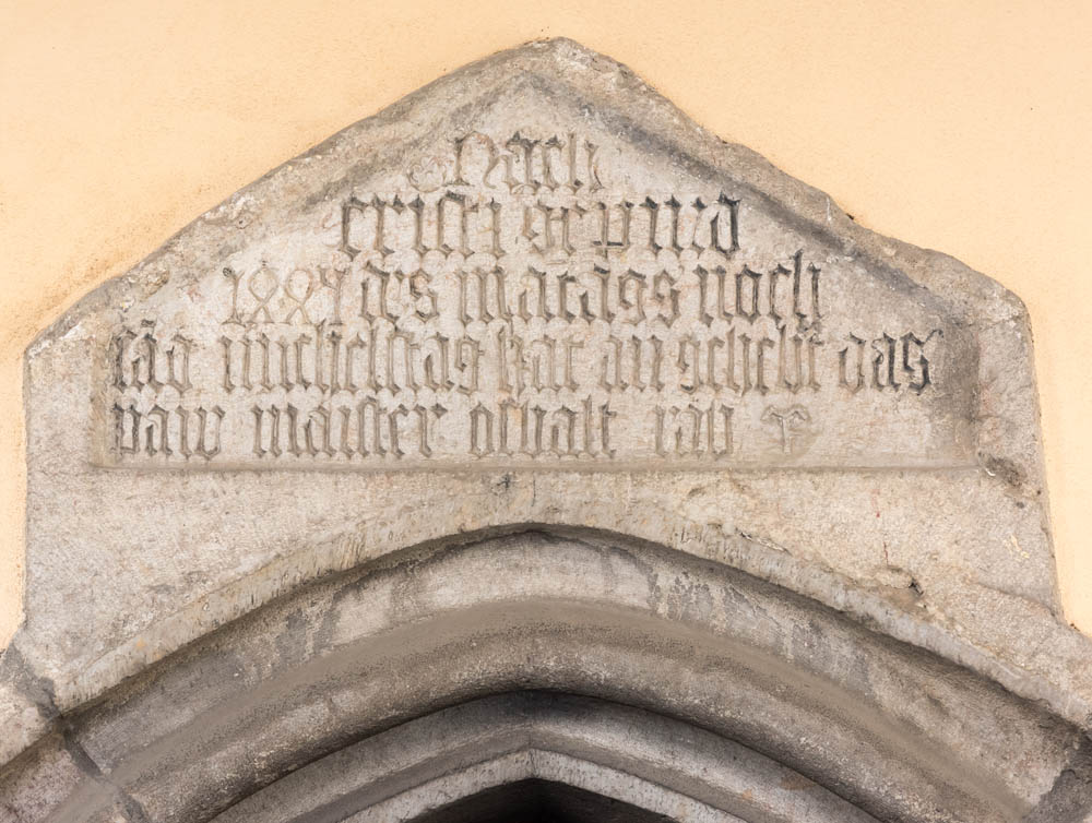 Parrocchiale Santi Pietro e Paolo Iscrizione sul portale d'ingresso, sotto i portici della facciata. © Johann Jaritz u2013 CC BY-SA